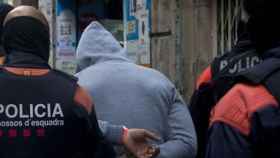 Agentes de Mossos se llevan a un detenido en una operación policial / EFE