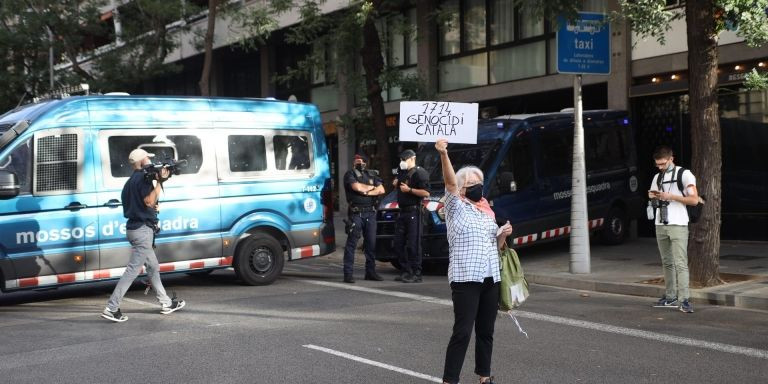 Una manifestante por el arresto de Puigdemont frente a coches de Mossos / EUROPA PRESS