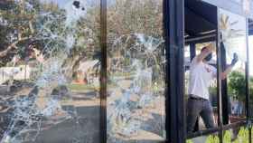 El propietario de un local afectado por el vandalismo durante las fiestas de la Mercè retira una cristalera de su establecimiento / EFE