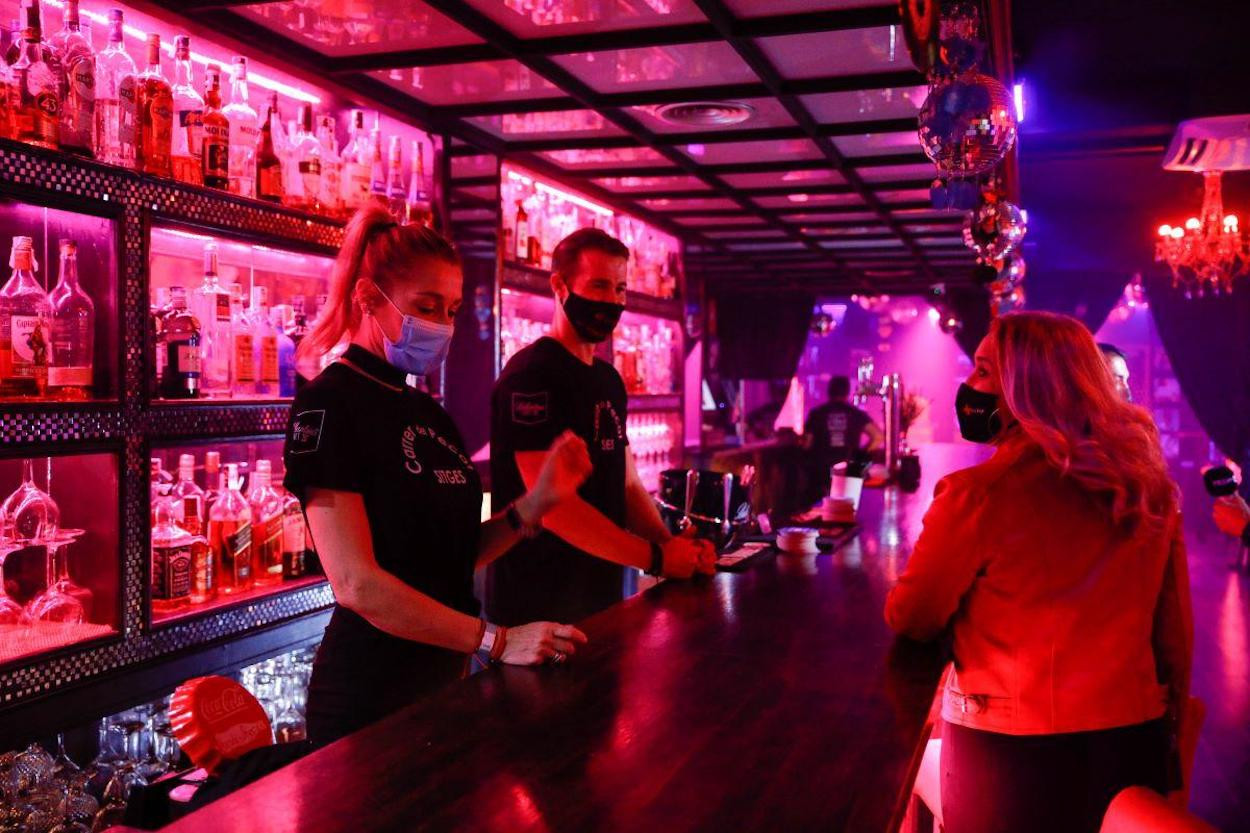 Una clienta y dos camareros con mascarilla en una discoteca / EUROPA PRESS