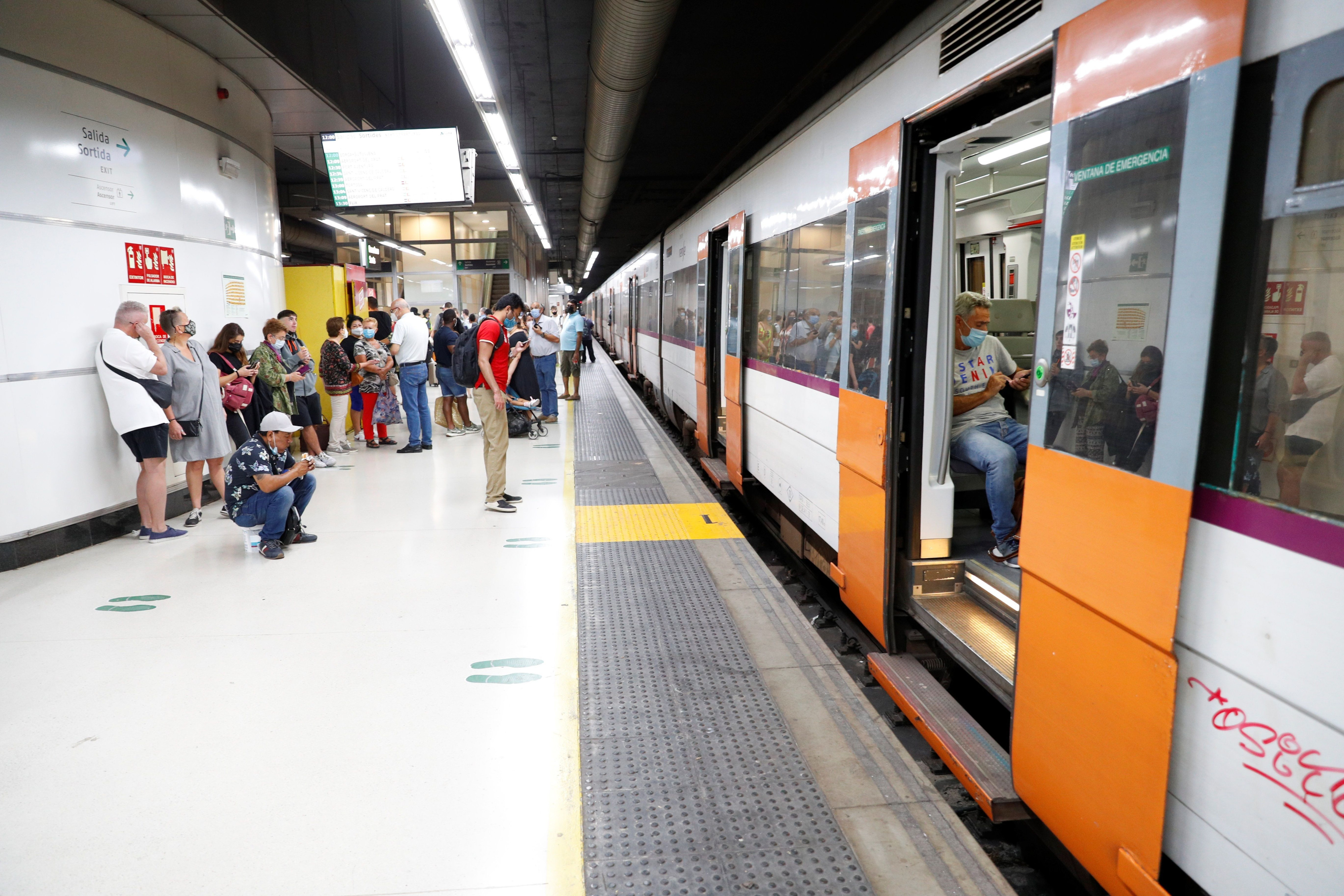 Varios pasajeros esperan ante un tren parado en la estación de Sants / EFE / Alejandro García
