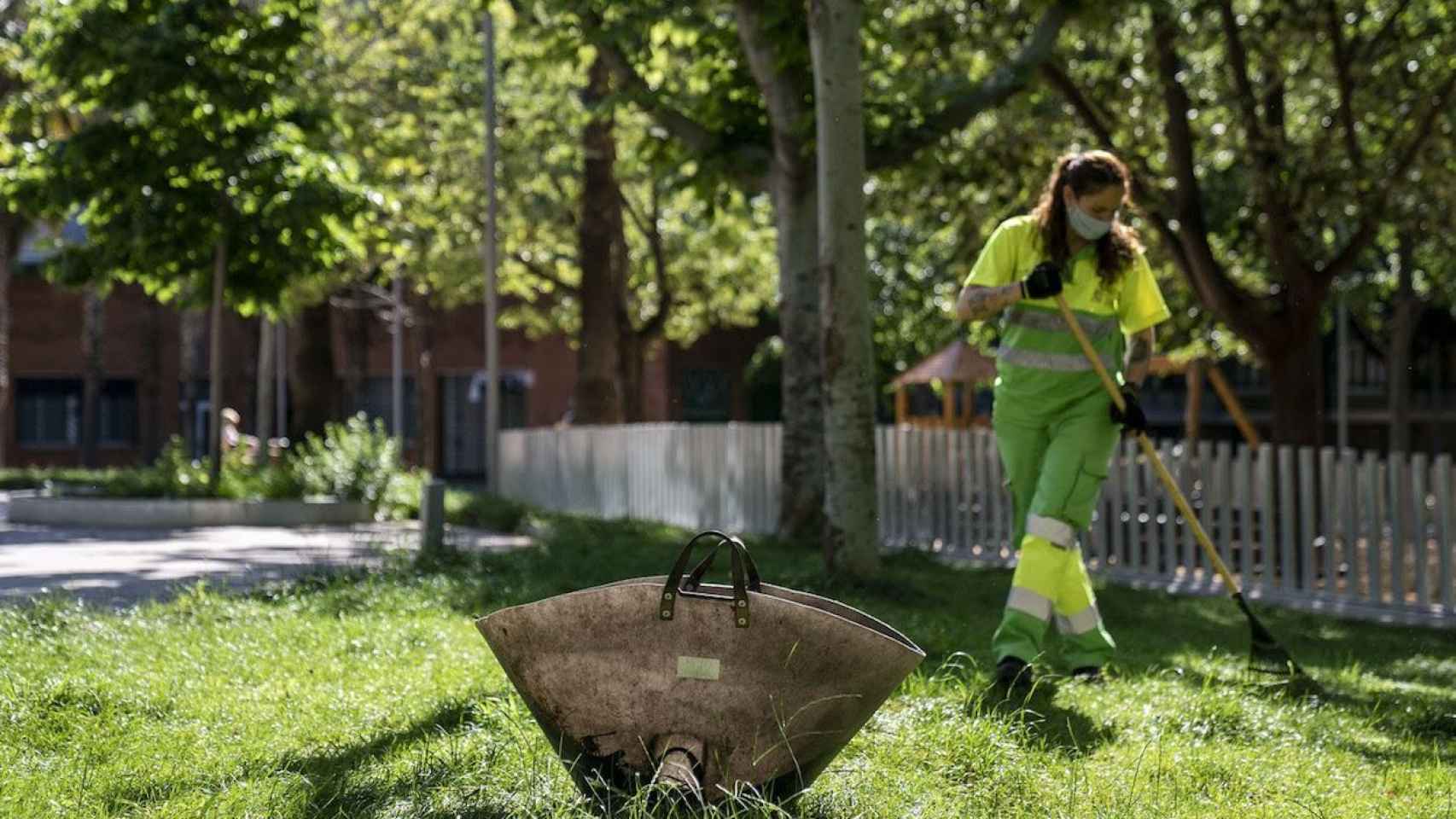 Una efectiva de limpieza recogiendo hojas secas en un parque / AYUNTAMIENTO DE BARCELONA