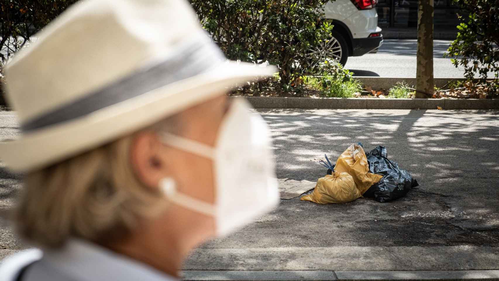 Una mujer pasa por delante de unas bolsas de basura tiradas por la calle / PABLO MIRANZO - MA