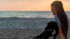 Una chica juega con su perro en la playa: la razón por la que las mascotas provocan alergias / PEXELS