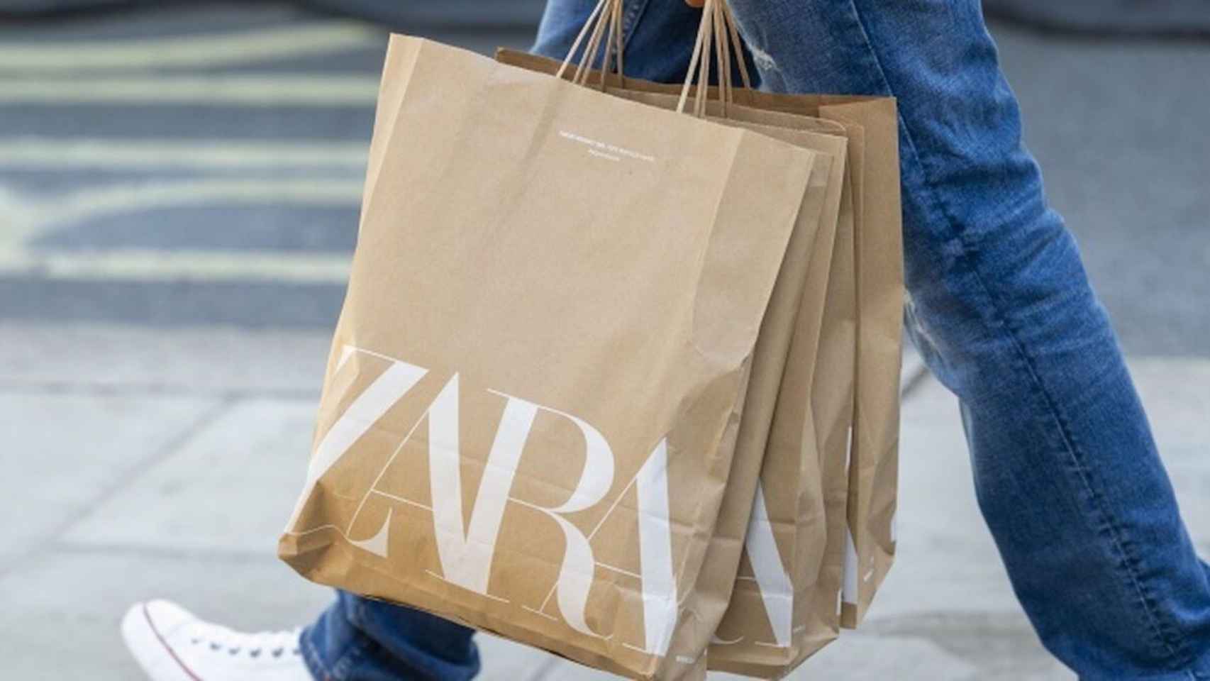 Una persona pasea con varias bolsas de papel de Zara, una de las marcas de Inditex