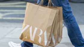 Una persona pasea con varias bolsas de papel de Zara, una de las marcas de Inditex