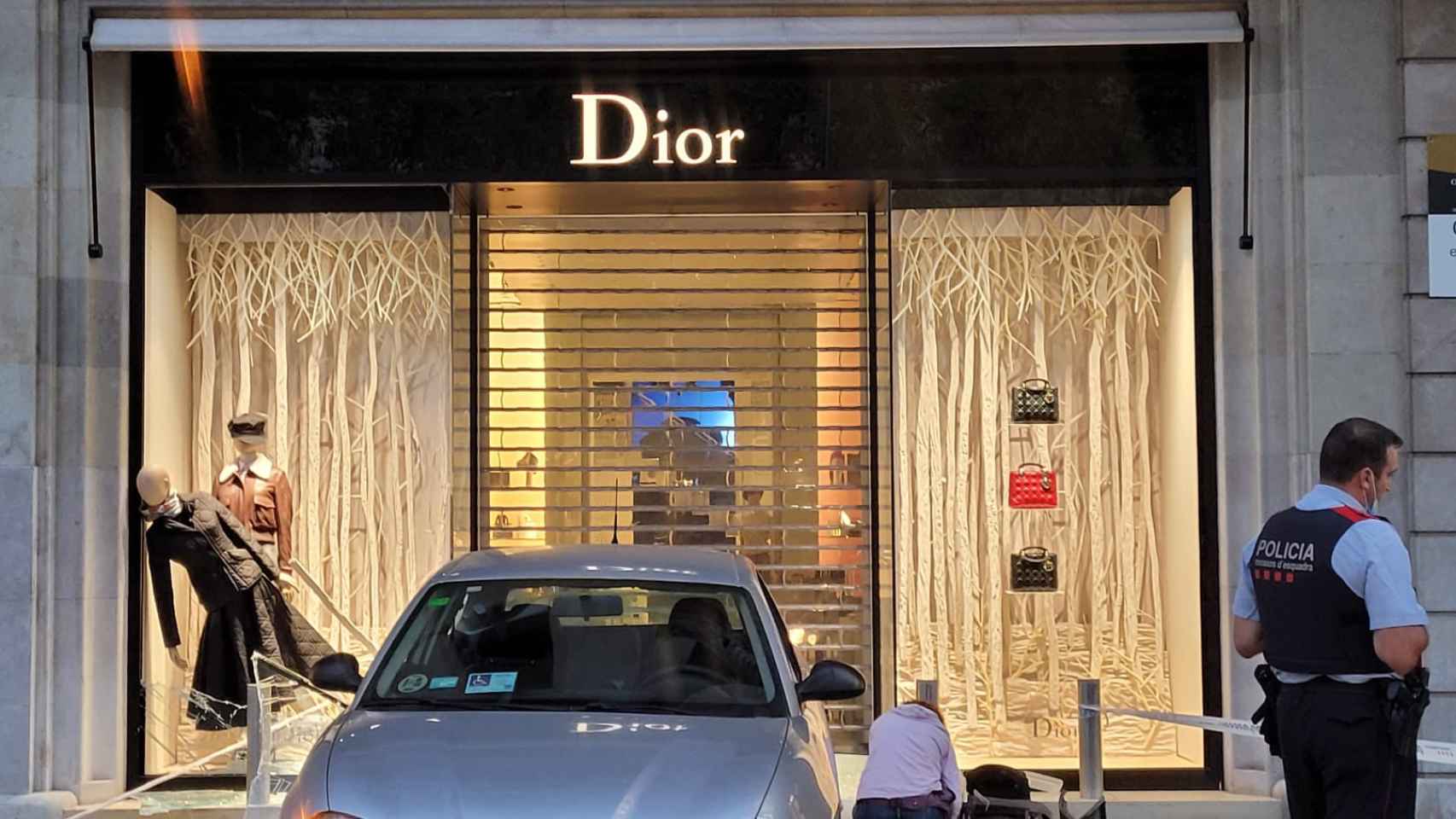 Agentes de los Mossos d'Esquadra junto al coche empotrado contra el escaparate de Dior / METRÓPOLI