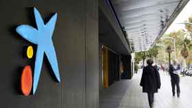 Dos personas pasan por delante de una oficina de CaixaBank: los clientes de Bankia afrontan la integración tecnológica / CAIXABANK