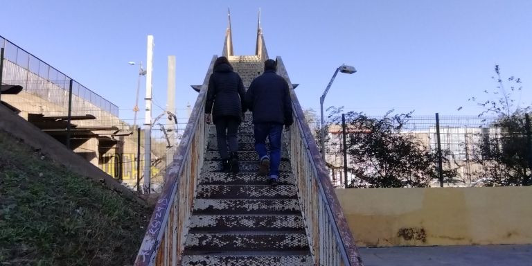 Vega y Orozco suben las escaleras del puente de la vía Trajana / METRÓPOLI - JORDI SUBIRANA