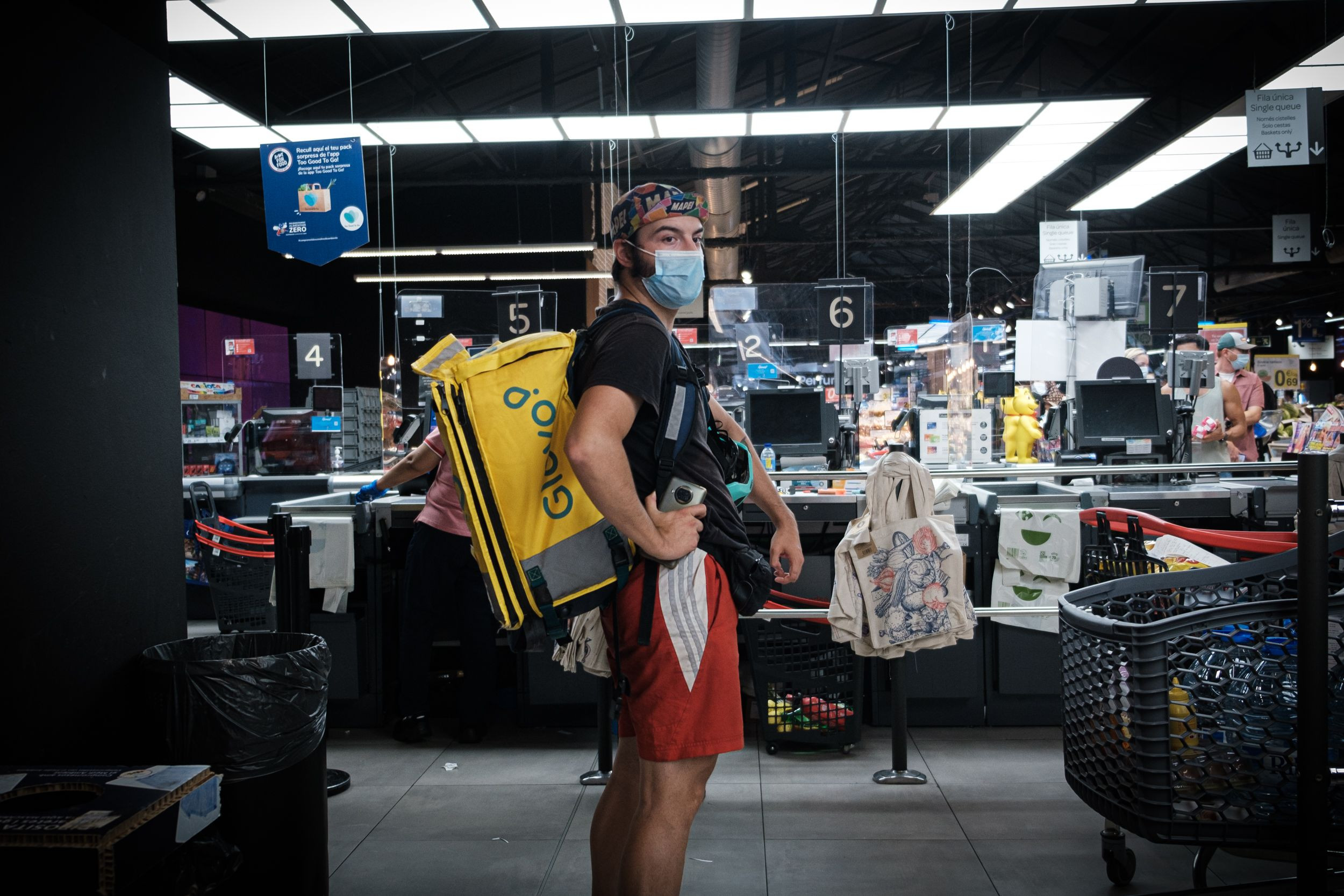 Javier Pérez, 'rider' de Glovo y Uber Eats, espera una compra a domicilio en un supermercado de La Rambla / PABLO MIRANZO