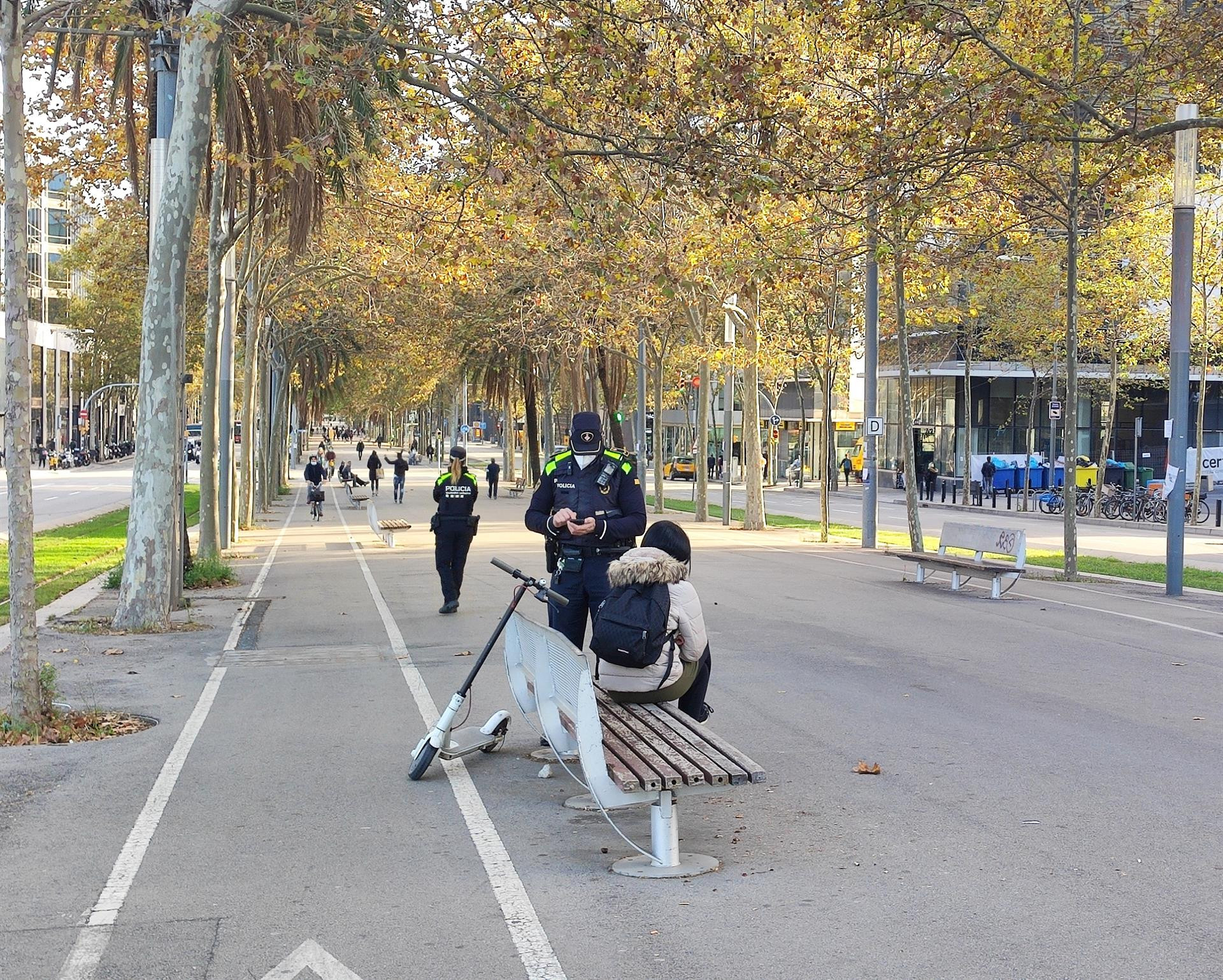 Un agente de la Guardia Urbana multa a una usuaria de patinete eléctrico en Barcelona / EUROPA PRESS