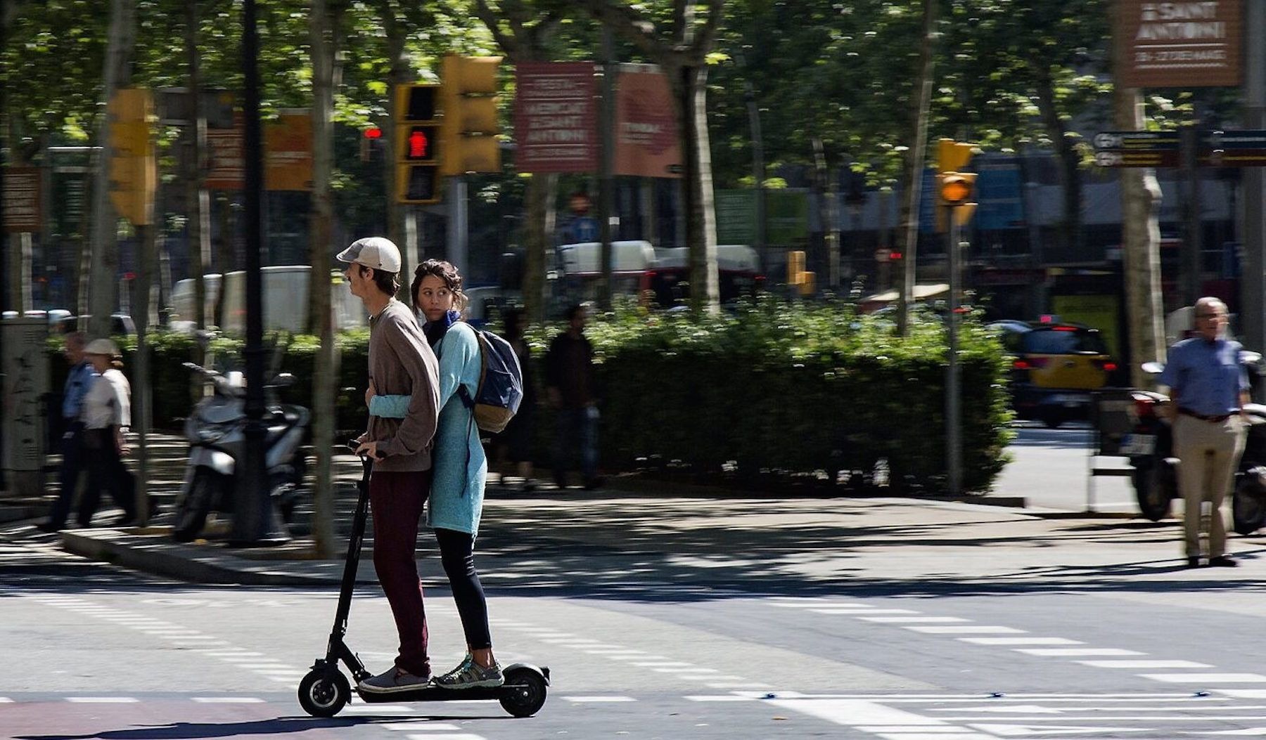 Dos usuarios en un patinete eléctrico circulando por Barcelona