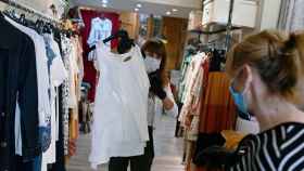Una vendedora y una clienta en la reapertura de tiendas durante la pandemia del covid-19 / EFE