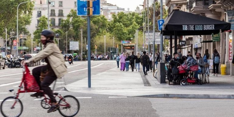 Una bicicleta pasa por delante de una terraza de bar en Barcelona / AJBCN