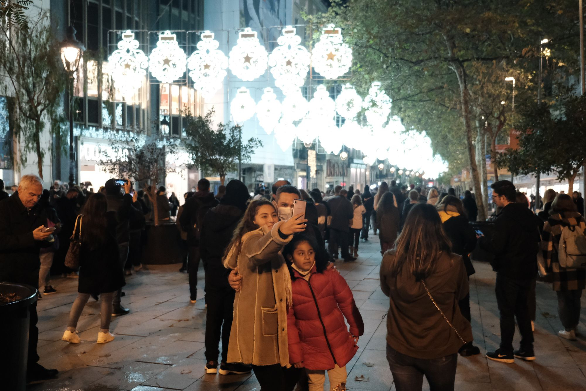 Una familia se hace un selfie bajo las luces de Navidad de Portal de l'Àngel / PABLO MIRANZO - MA