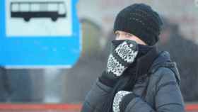 Una mujer, muy abrigada, se cubre el rostro para protegerse del frío / Andrzej Hrechorowics / EFE