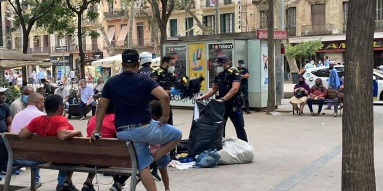 Agentes de la Guardia Urbana durante un registro en el 'mercado de la miseria' de Sant Antoni / METRÓPOLI