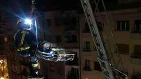 Un bombero junto a una víctima evacuada con una grúa en Barcelona / TWITTER BOMBEROS