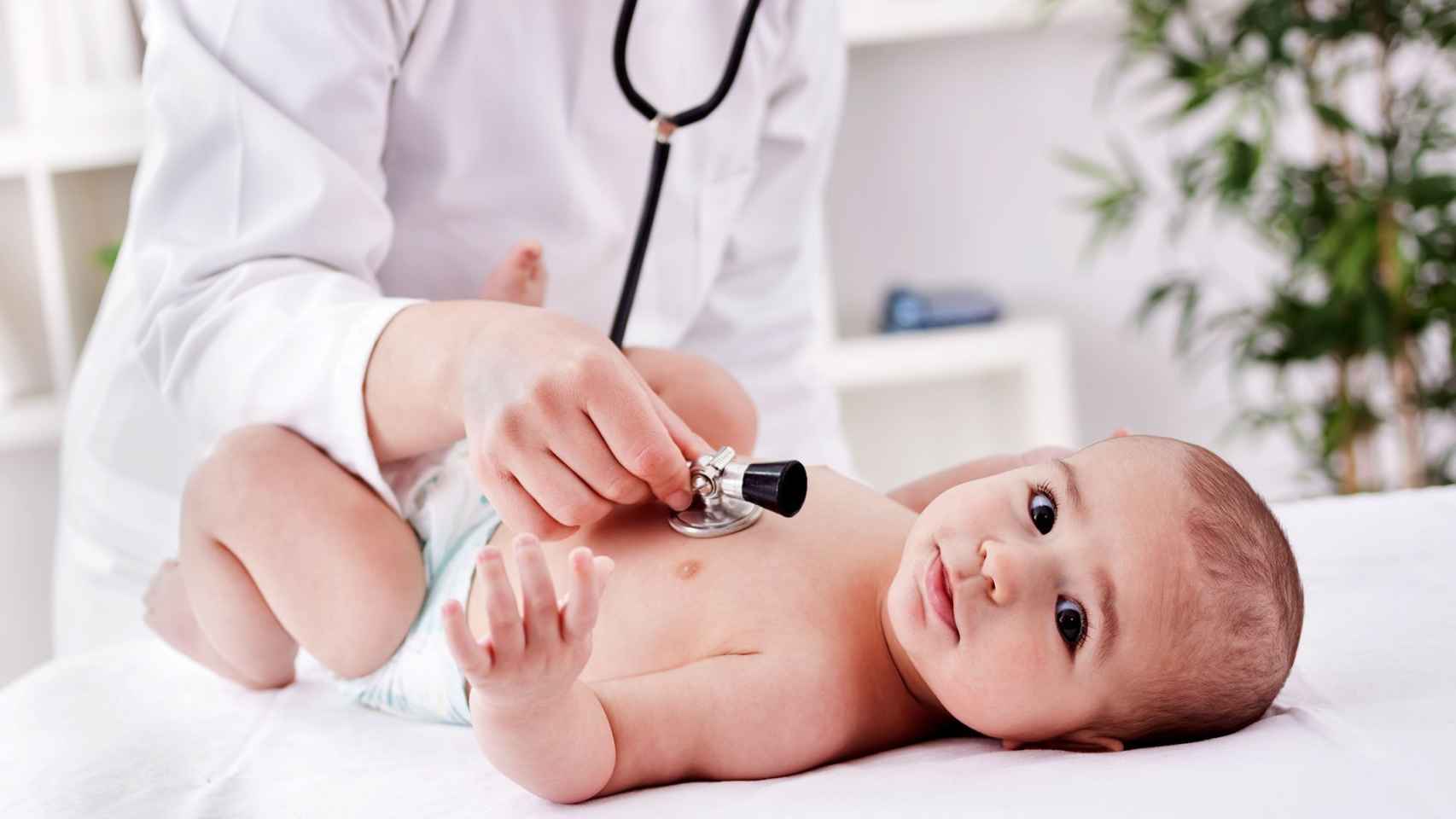 Un médico ausculta el pecho de un bebé, como se hace cuando tienen laringitis o bronquiolitis / QUIRÓNSALUD