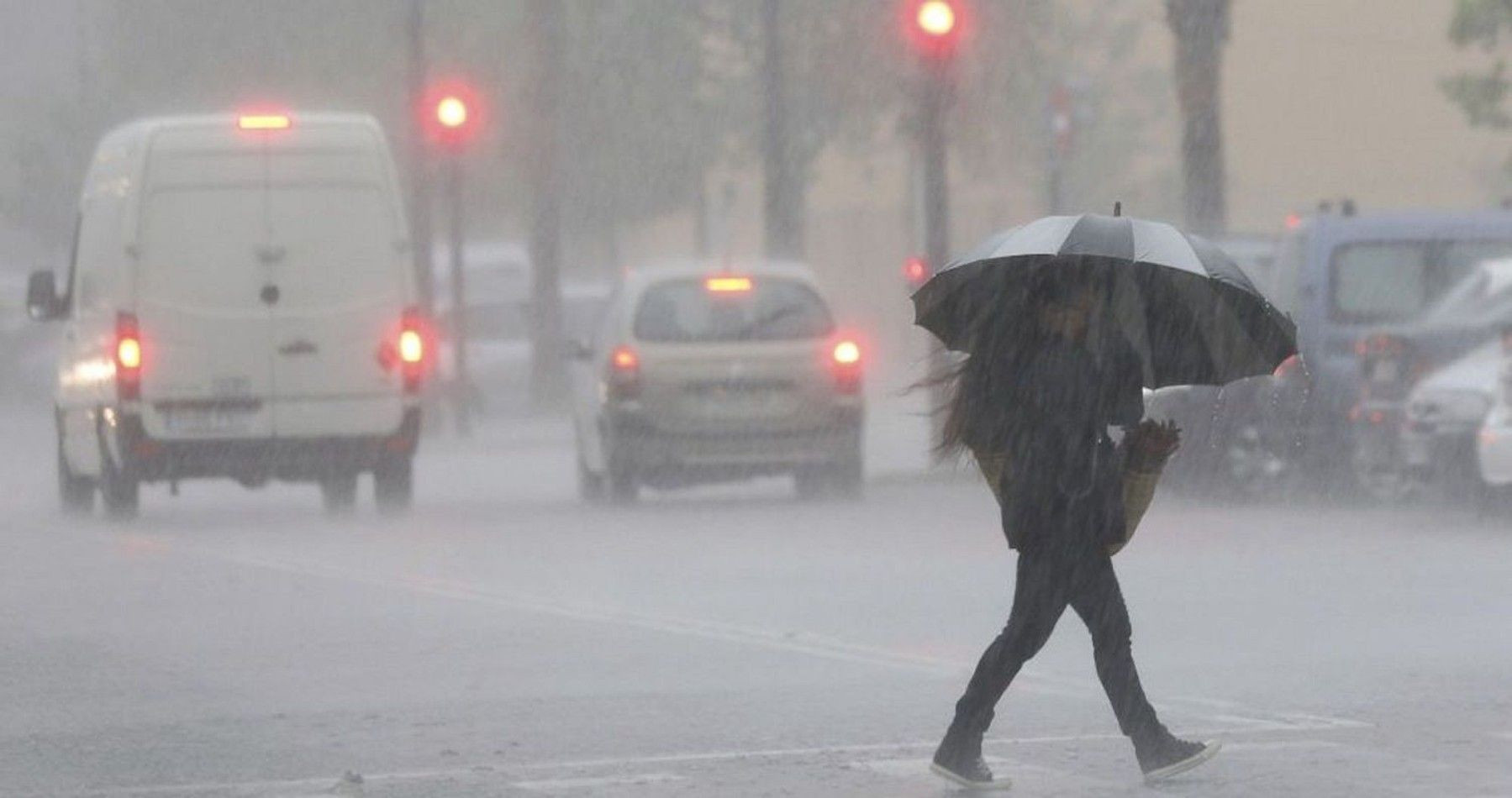 Una mujer se protege de la lluvia bajo un paraguas en Barcelona / EFE