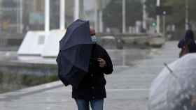 Un hombre con un paraguas camina por el paseo marítimo mientras llueve en A Coruña / M. Dylan - Europa Press