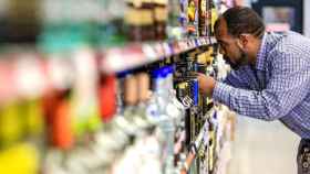 Un trabajador en un supermercado ordenando las botellas