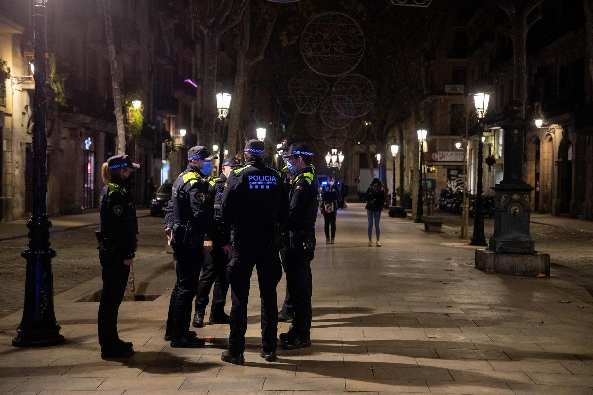 Agentes de la Guardia Urbana informando de la entrada en vigor del toque de queda en Nochebuena - Kike Rincon / Europa Press