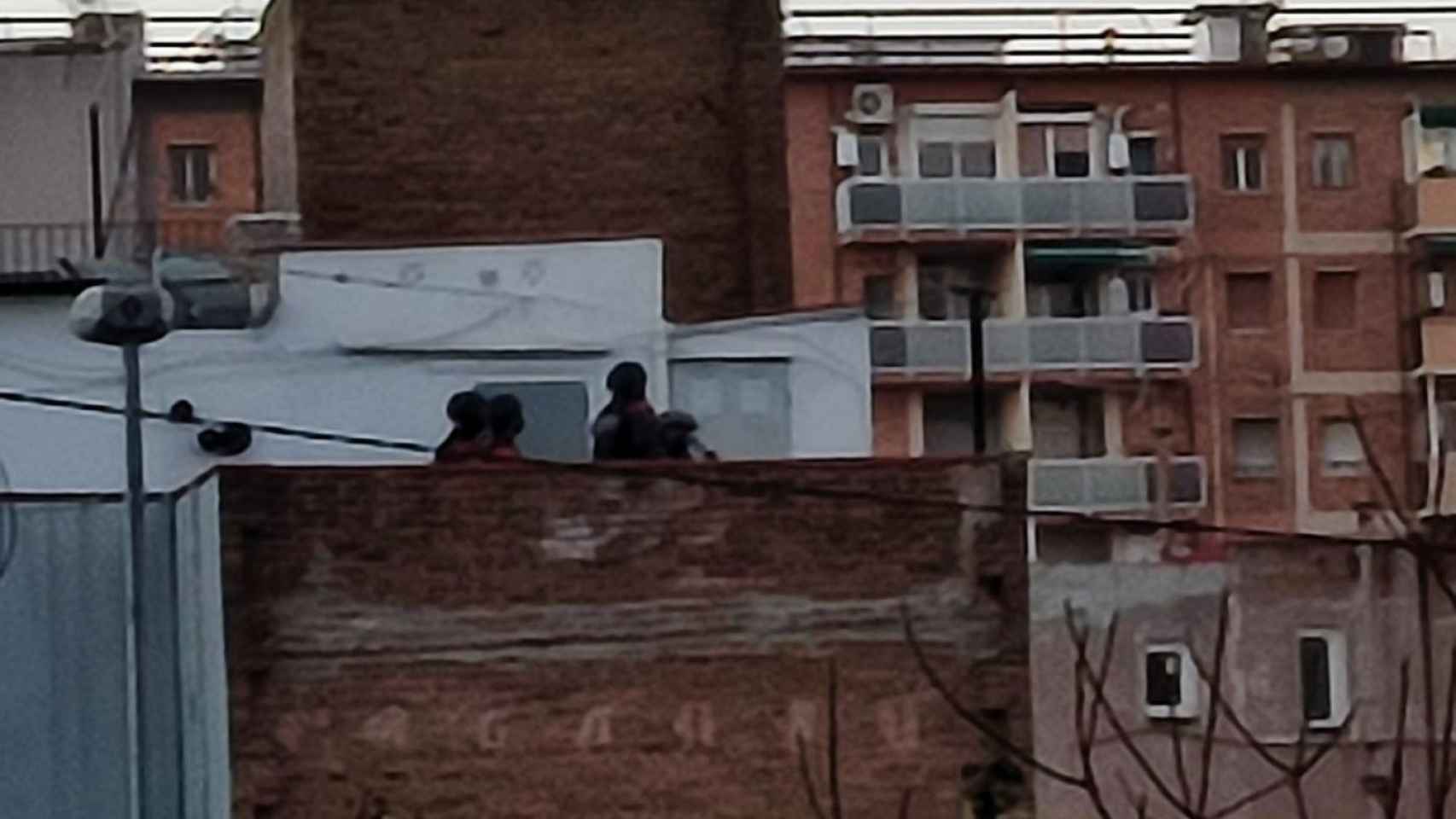 Agentes de los Mossos d'Esquadra observan desde una azotea el domicilio donde un hombre se ha atrincherado / METRÓPOLI