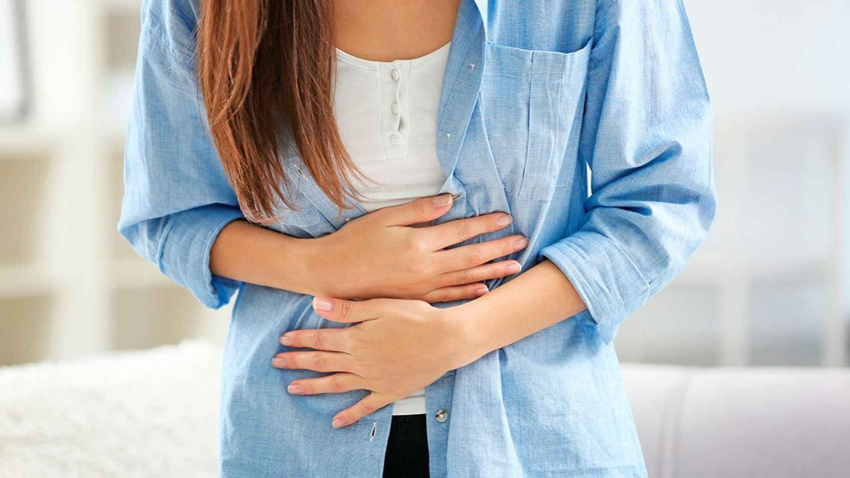 Una mujer se queja de dolor ovárico: la endometriosis puede afectar a la fertilidad / QUIRÓNSALUD