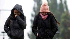 Dos chicas bien abrigadas pasean por la calle en un día de mucho frío / EFE
