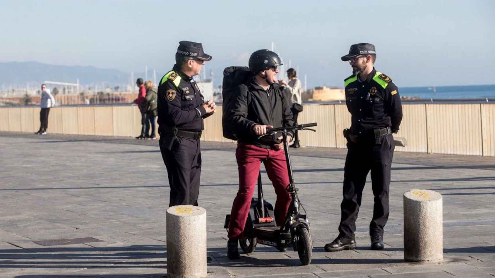 Un usuario de patinete y dos agentes de la Guardia Urbana en una imagen de archivo / EFE