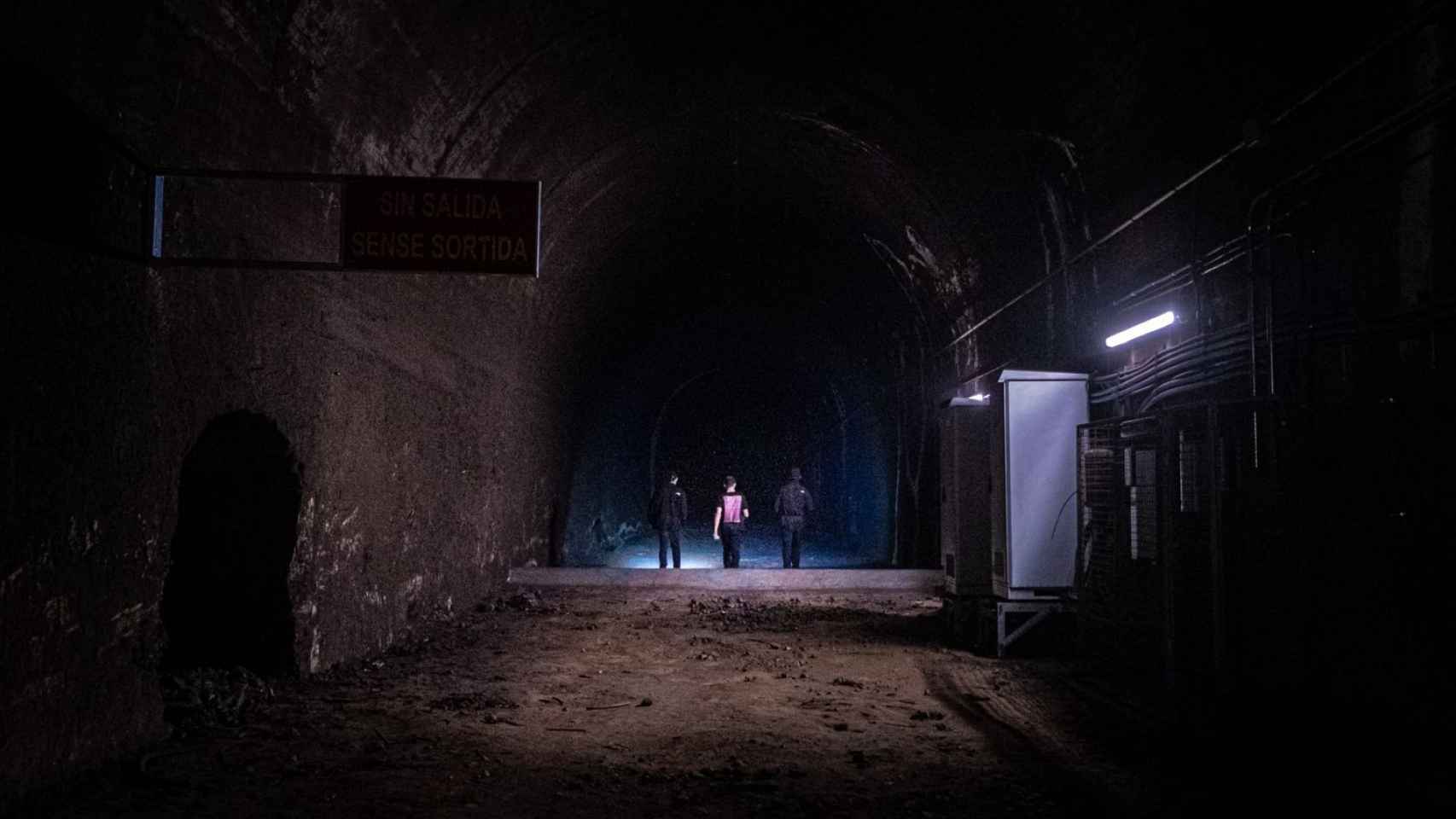 Los exploradores urbanos Abel, Pol y Gaxx caminan por un túnel paralelo a las vías del tren en Barcelona / PABLO MIRANZO