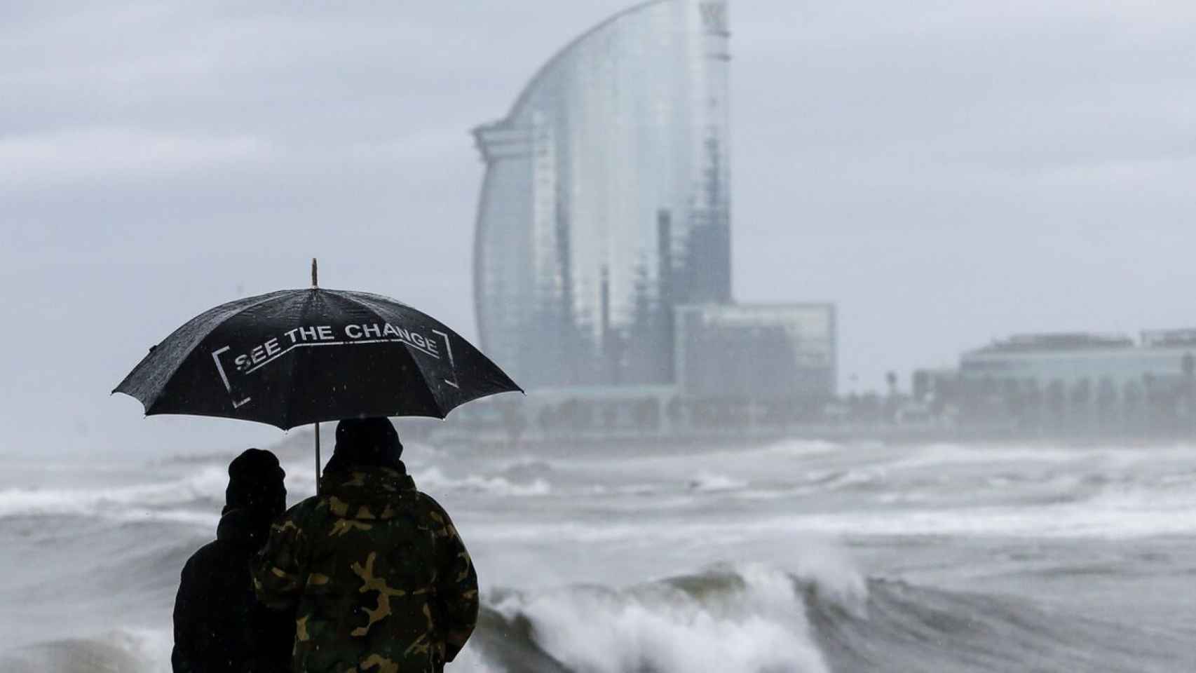 Personas observan las olas en Barcelona en una imagen de archivo