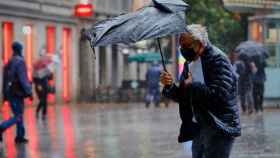 Un hombre pasea bajo la lluvia en la capital catalana / EUROPA PRESS
