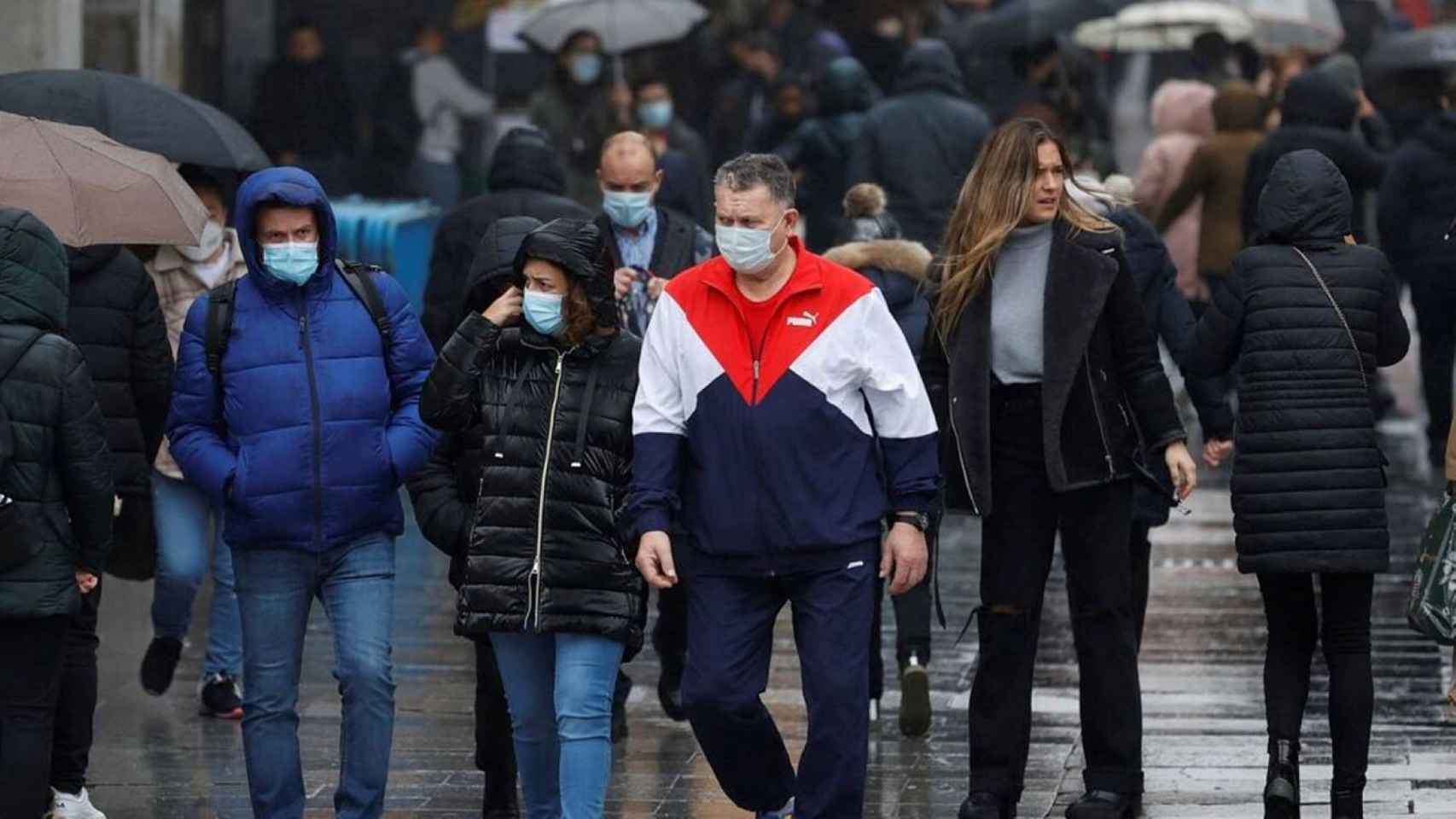Múltiples personas cubiertas con mascarilla paseando por la calle / EFE