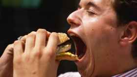 Un hombre comiéndose una hamburguesa en una imagen de archivo / REDES SOCIALES
