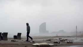 Un hombre pasea por la Barceloneta durante un temporal / EFE