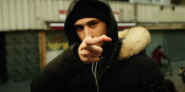 Uno de los participantes del videoclip haciendo un gesto de una pistola 