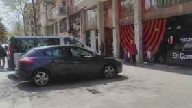 Dos coches aparcados en la acera frente a la sede de los comunes impiden el paso / TWITTER (@jm_clavero)