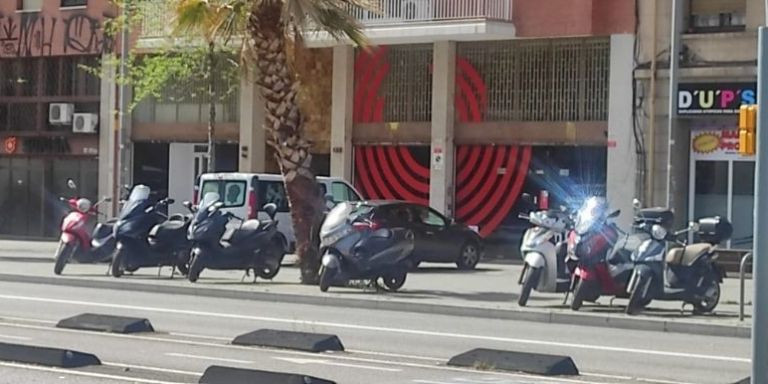 Coches mal aparcados en la sede de En Comú Podem / TWITTER ON VAS STOP COLAU