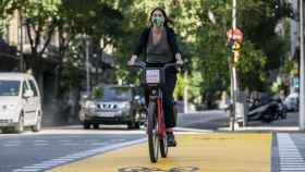 Una ciclista con mascarilla en Bicing por la calle de Pau Claris / AYUNTAMIENTO DE BARCELONA