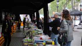 Personas comprando libros en una parada durante la 'diada' de Sant Jordi / LUIS MIGUEL AÑÓN