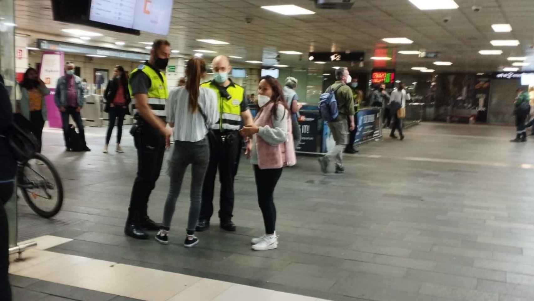 Vigilantes de seguridad hablan con dos presuntas carteristas en la estación de plaza Catalunya / METRÓPOLI