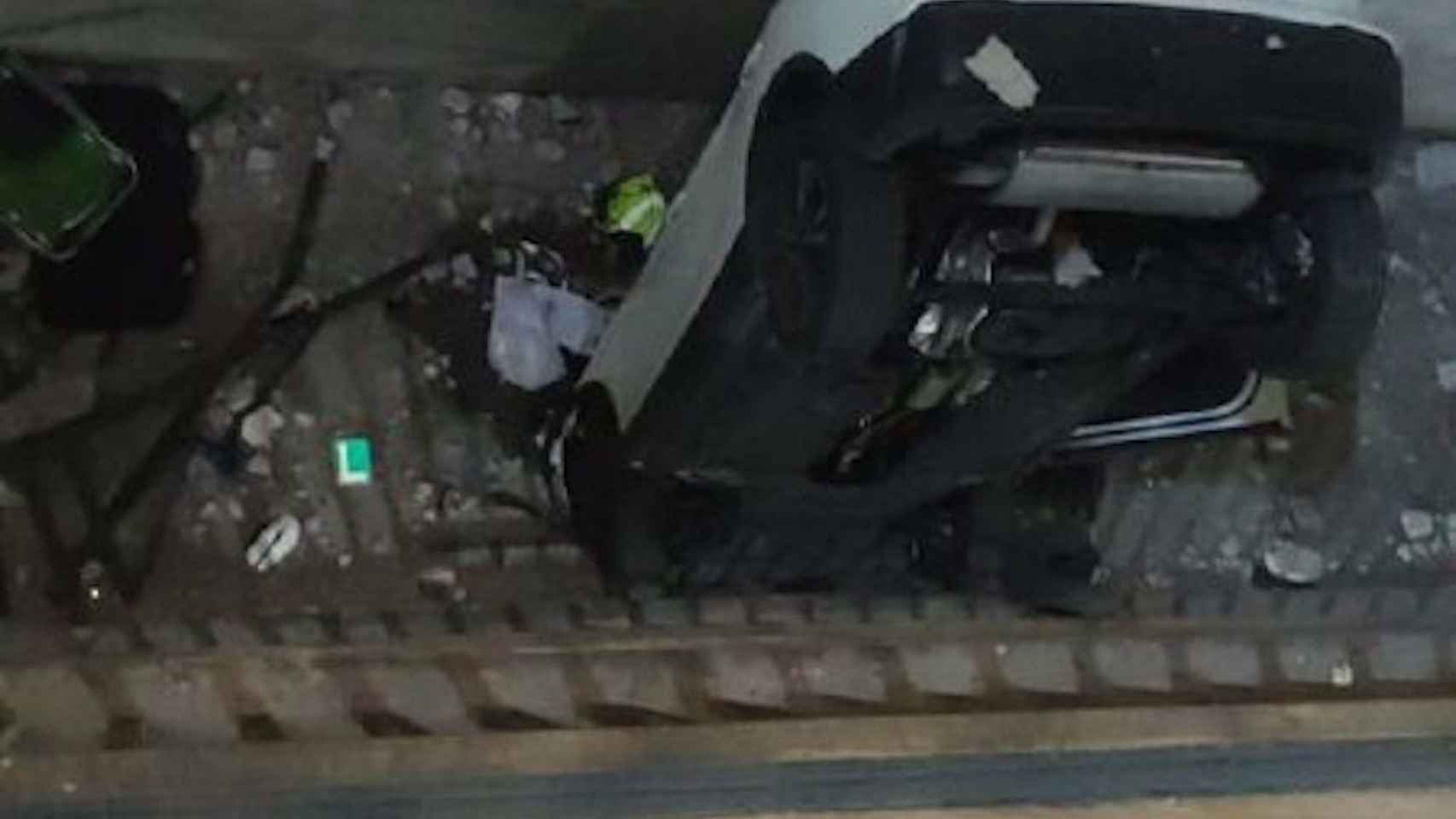 El coche que ha caído desde una altura de dos pisos en un parking de la calle Urgell / BOMBERS DE BARCELONA