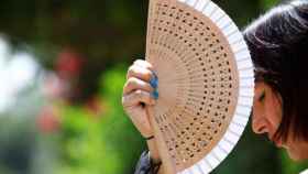 Una mujer hace pasar el calor con un abanico en una imagen de archivo / EFE