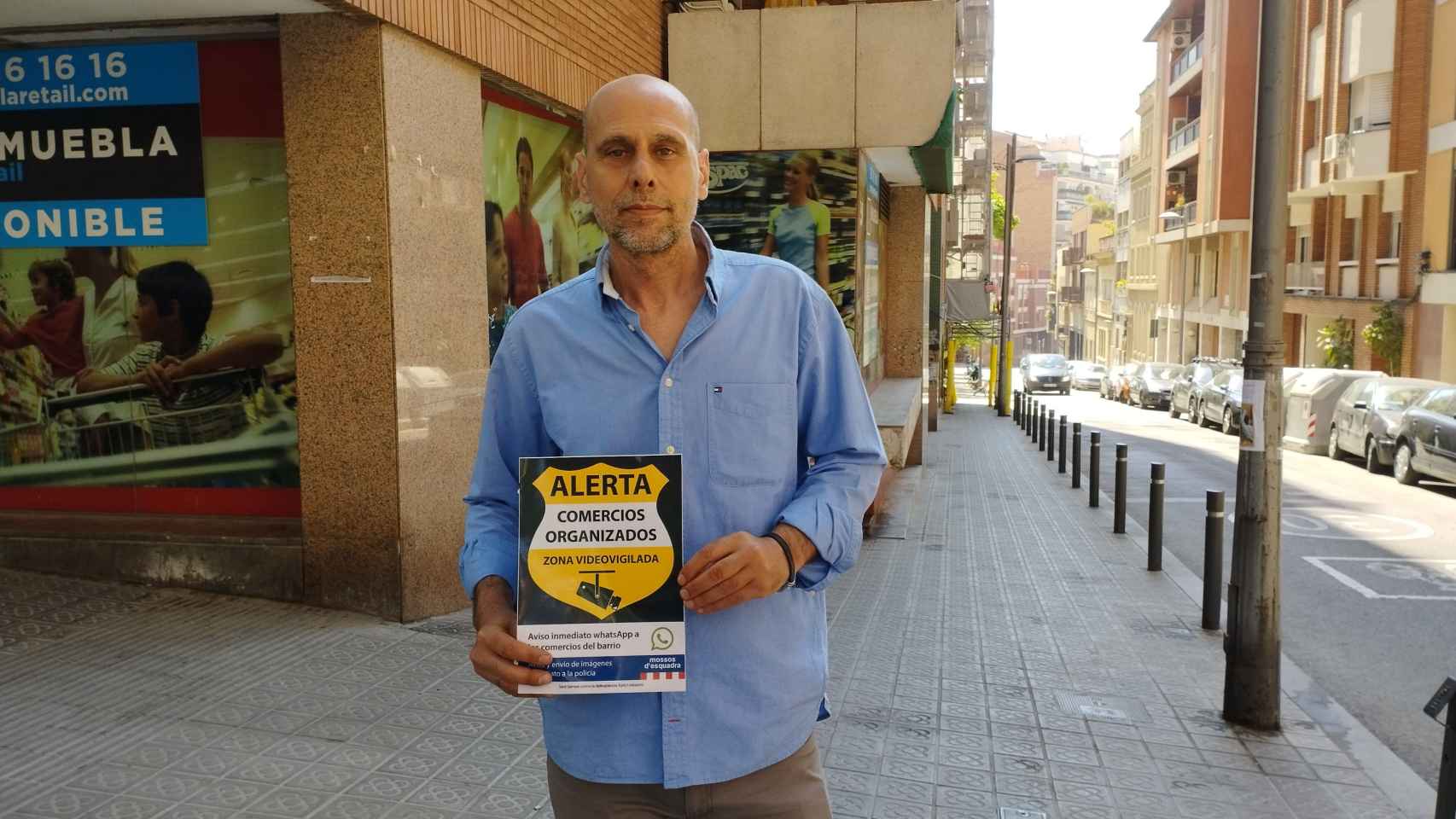 José Carlos Raso, comerciante de Sant Gervasi, muestra uno de los carteles que lucen muchos comercios del barrio / METRÓPOLI