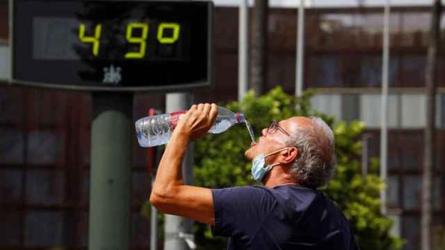 Un hombre bebe agua en plena ola de calor / EFE