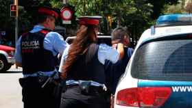 Dos agentes de los Mossos, arrestando a una persona por un presunto robo / EP