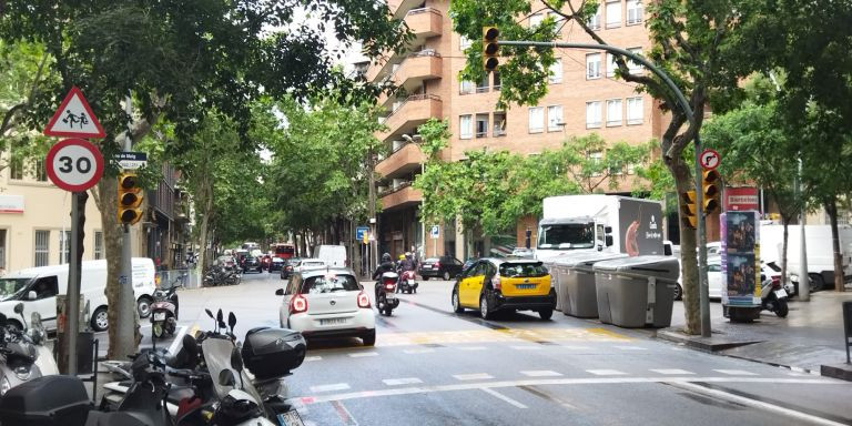 Coches y motos tras pasar el semáforo estropeado de la calle de Mallorca, en Barcelona / METRÓPOLI - JORDI SUBIRANA