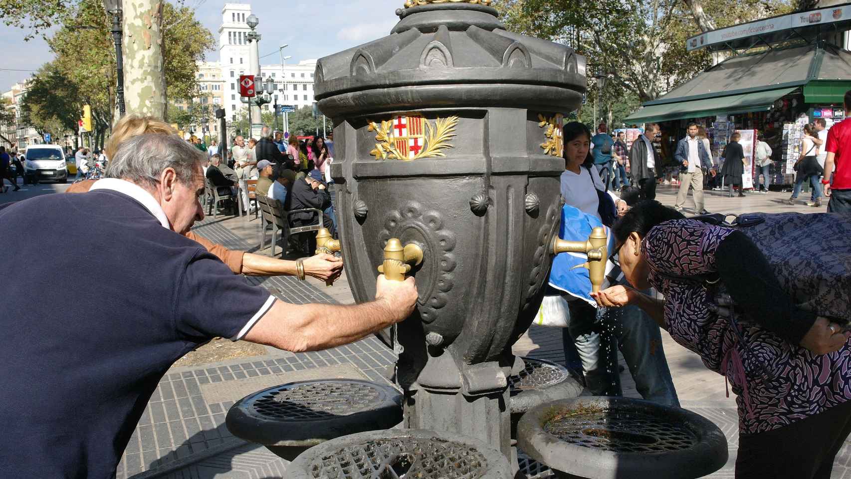 Dos personas se refrescan en la Fuente de Canaletas de Barcelona / AYUNTAMIENTO DE BARCELONA